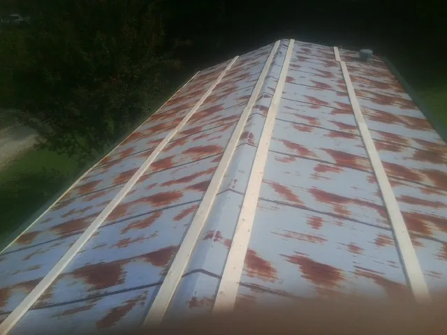 Rusted metal roof panels with new wood purlins before replacement — Storm Damage Roof Repair in Ford by Roofing Brothers