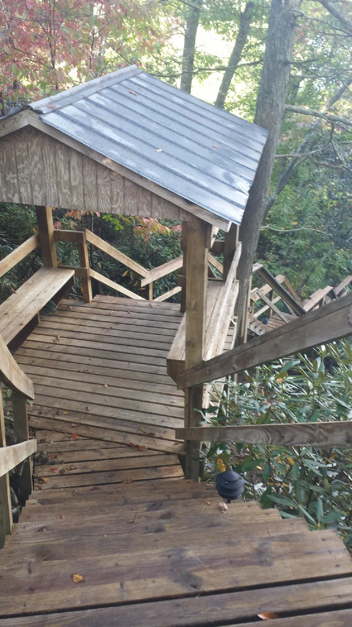 Metal roofed shelter over wooden steps on a wooded walkway — Skylight Repair & Installation work by our crew in Ford