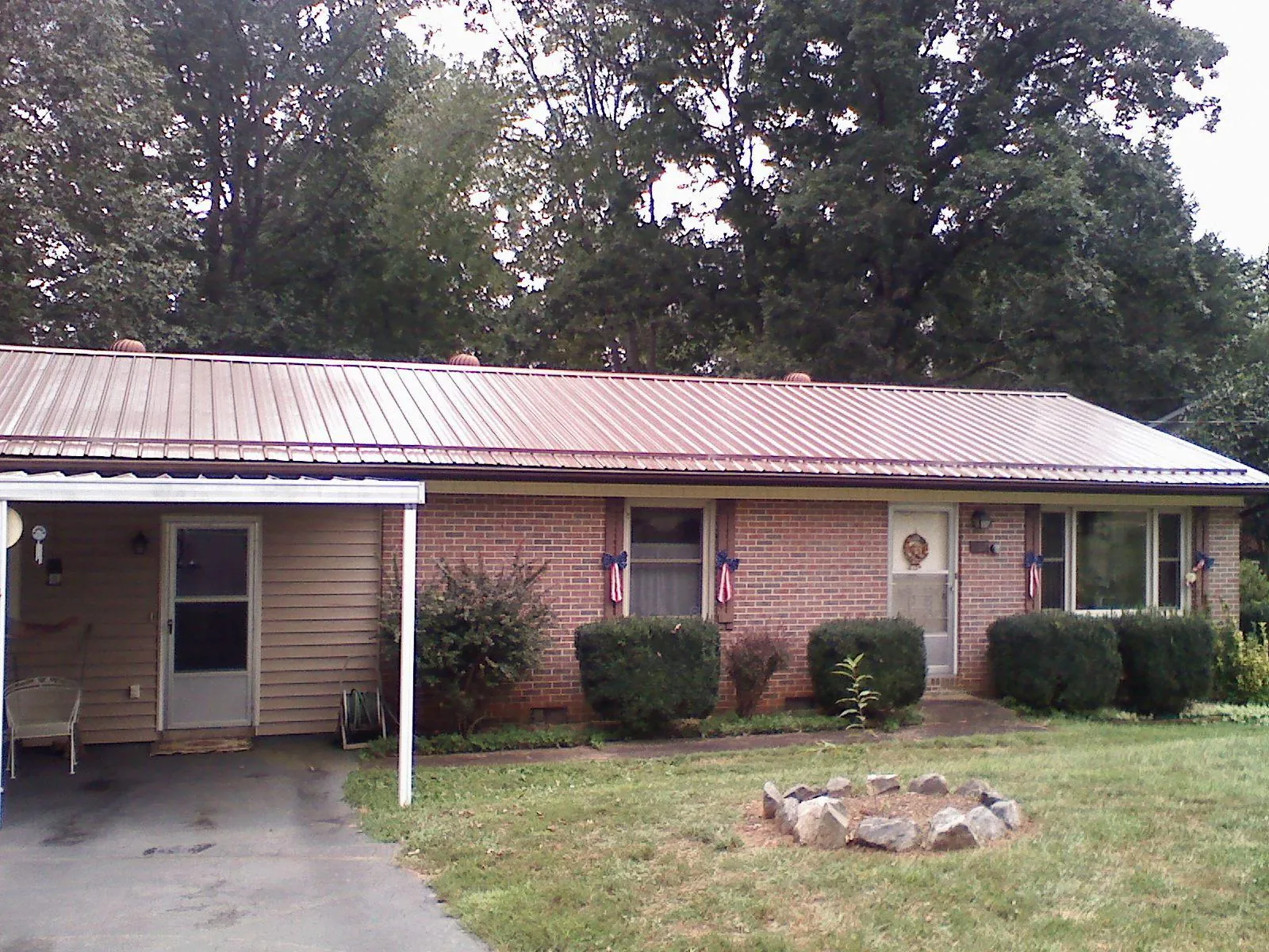 Bronze metal roof and carport on a brick ranch home — Roof Repair work by our crew in Ford