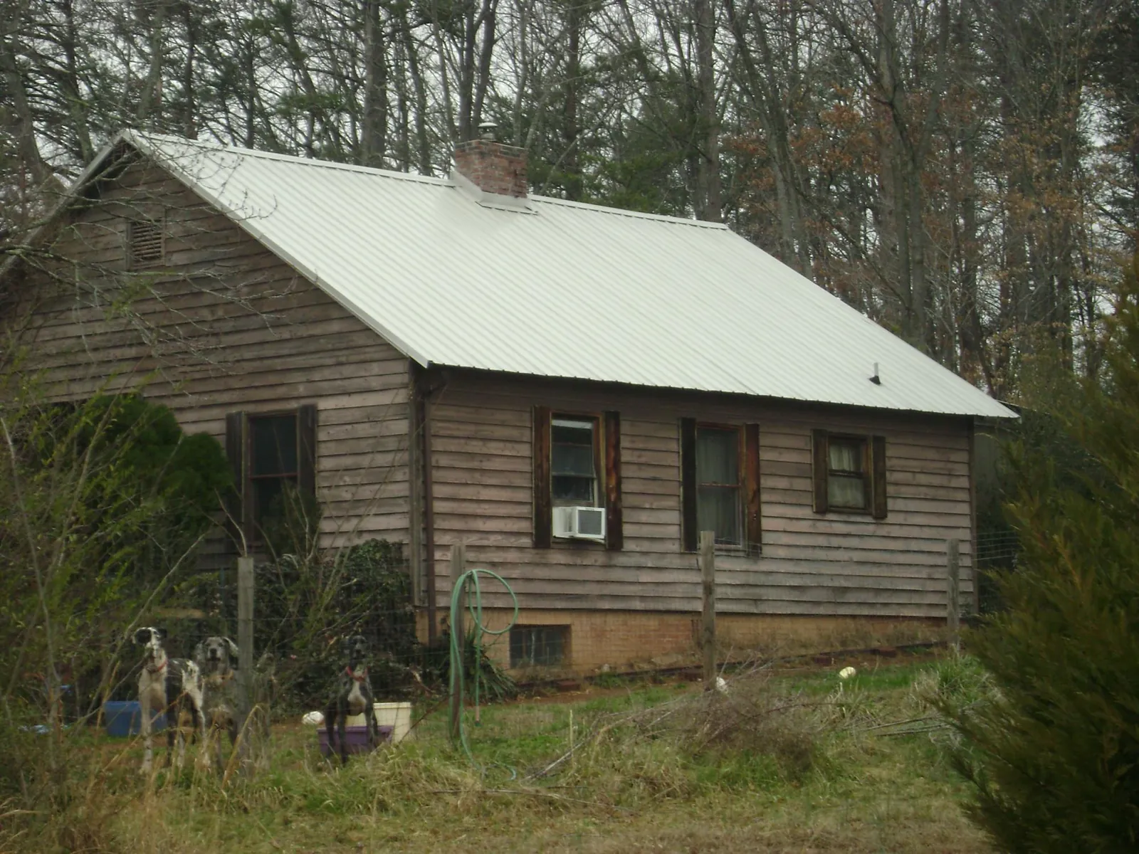 White metal roof on an old wood sided farmhouse, from a Metal Roof Installation job in Ford